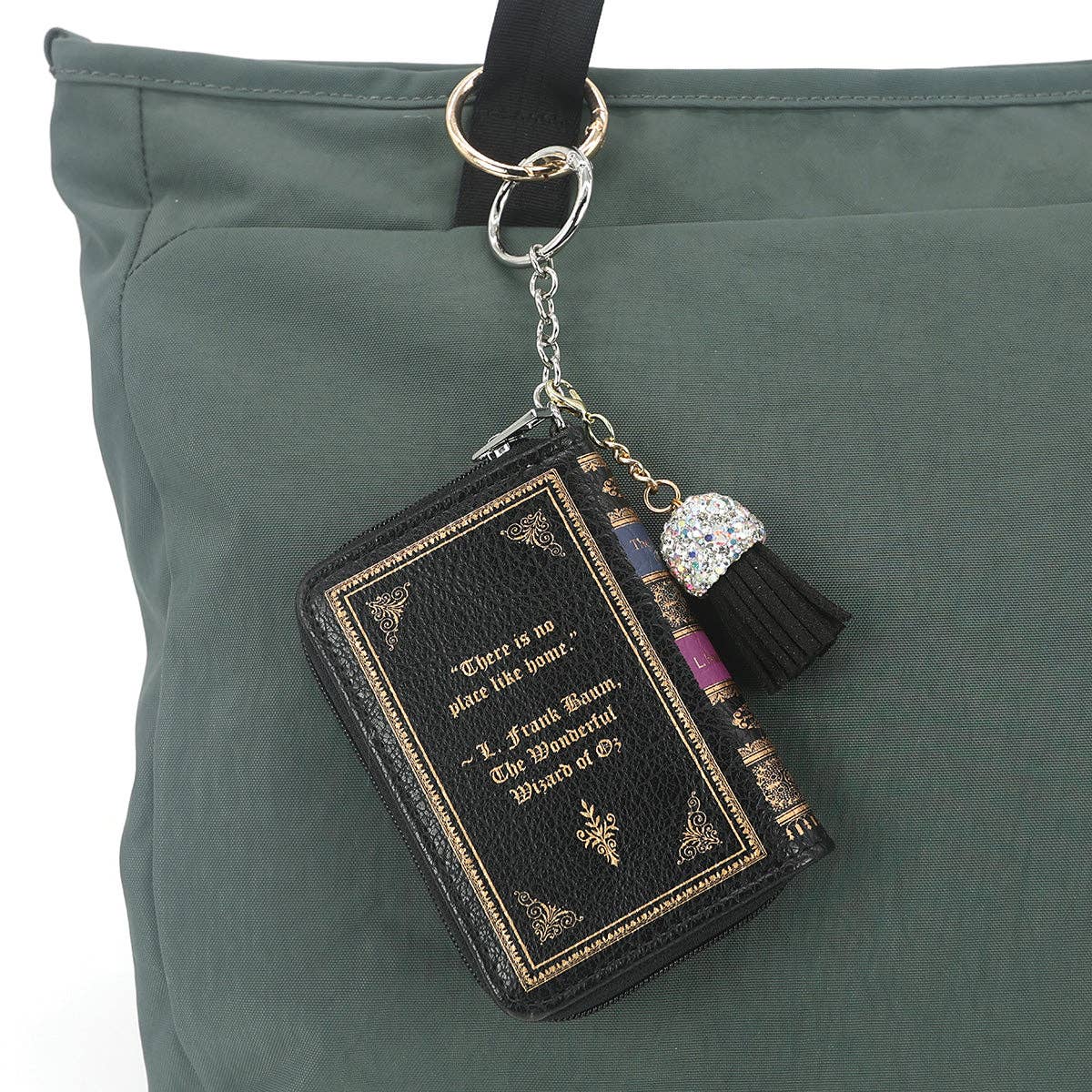 Book-shaped keychain with tassel on a green bag