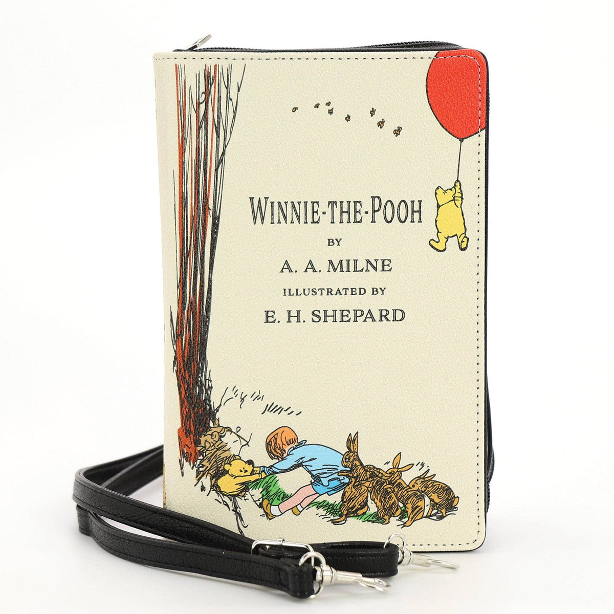 The House at Pooh Corner book clutch crossbody purse in beige, with classic Winnie-the-Pooh illustrated cover artwork and detachable carrying straps.
