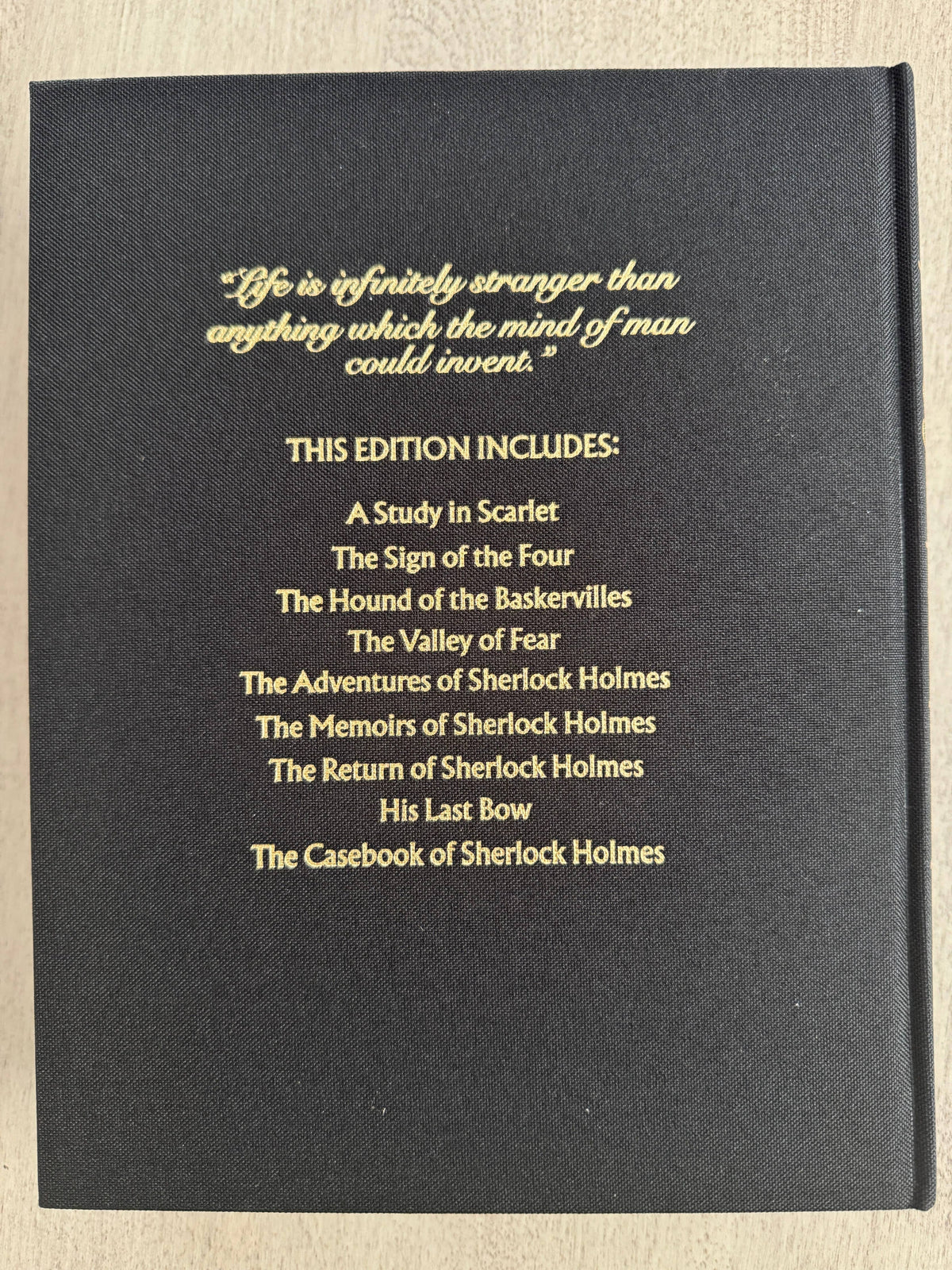 Black book cover with gold text listing Sherlock Holmes stories on a beige background