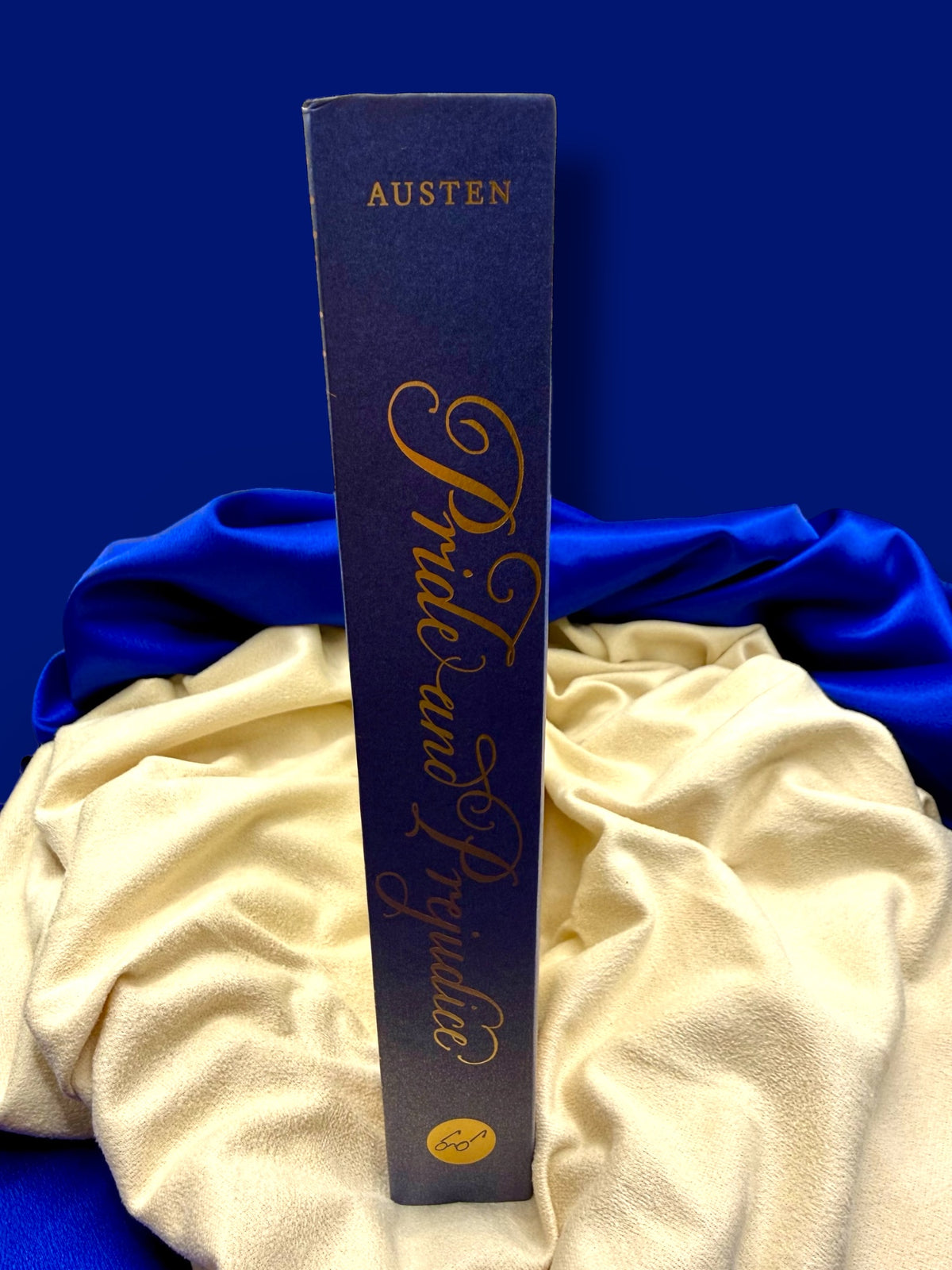 Spine of Pride and Prejudice deluxe edition by Jane Austen, featuring an elegant dark blue binding with gold decorative details.