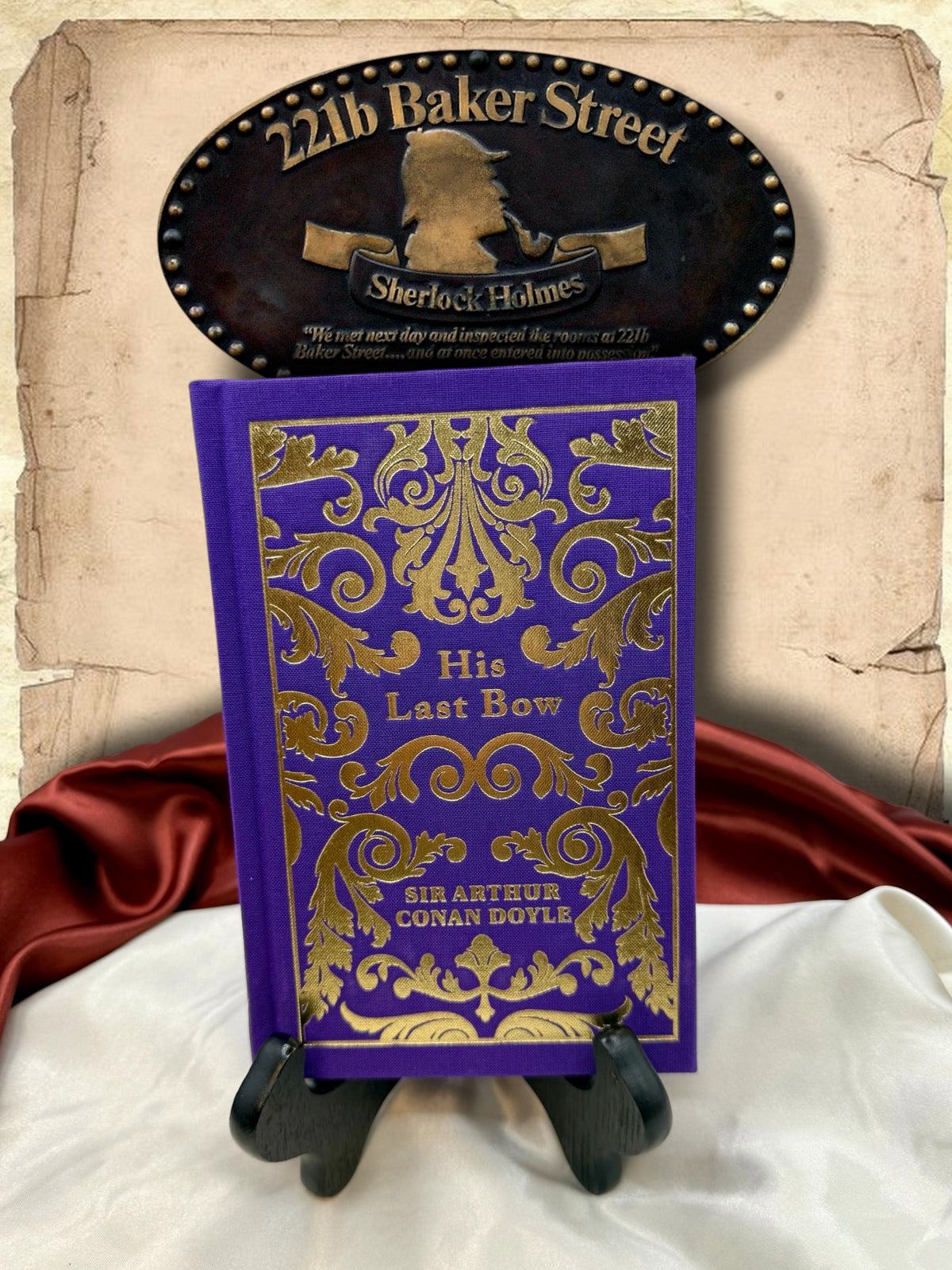 His Last Bow by Sir Arthur Conan Doyle, purple clothbound Sherlock Holmes hardcover with elaborate gold floral decoration, displayed beneath a 221B Baker Street sign.