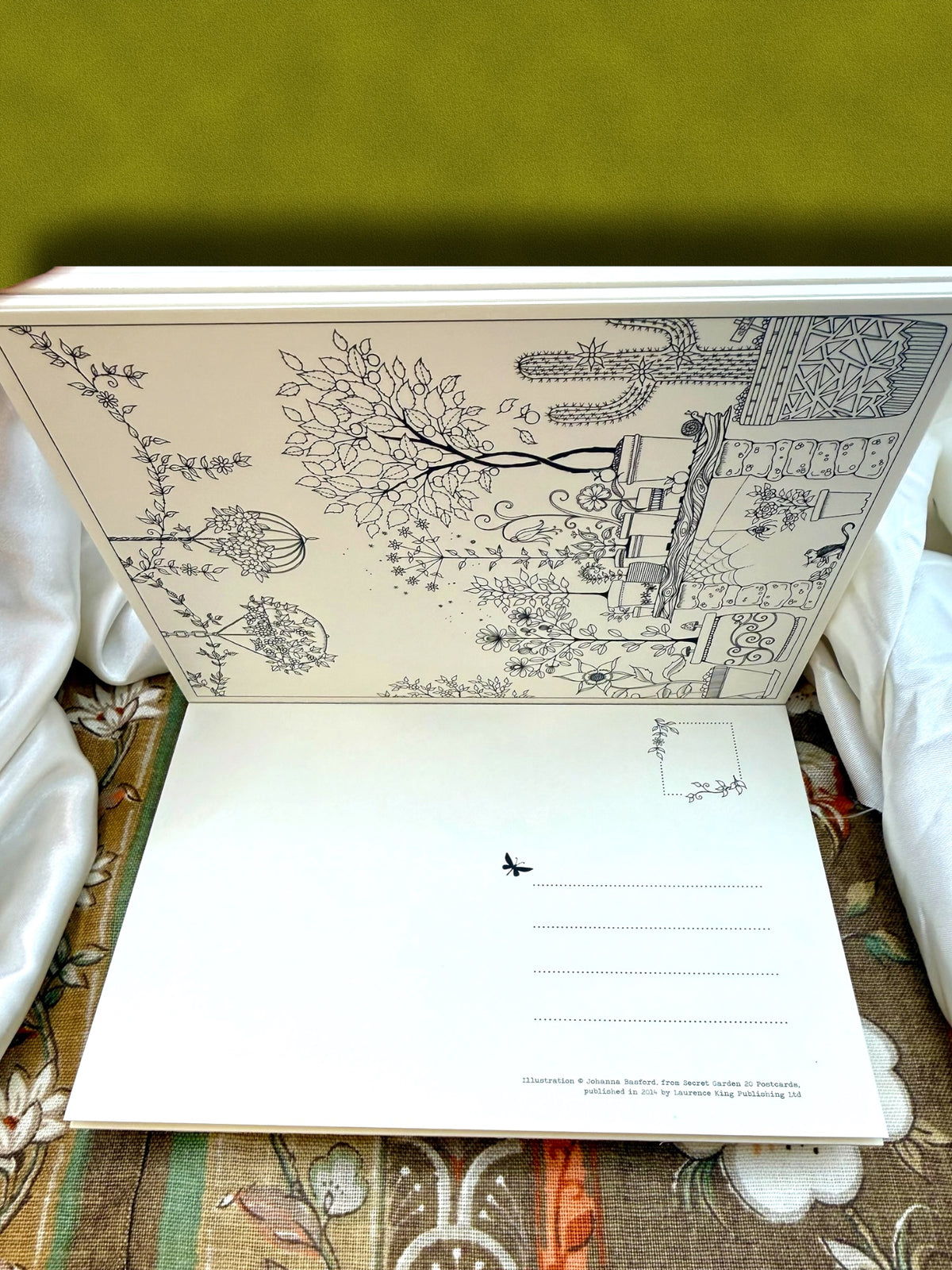 Secret Garden detachable coloring postcard book opened to show the illustrated postcard pages and paper format.