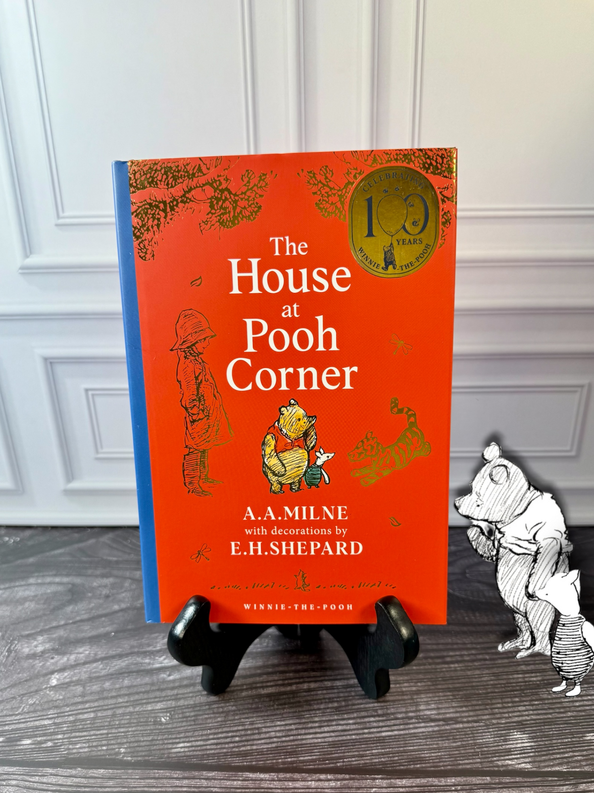 The House at Pooh Corner by A. A. Milne, 100th anniversary illustrated hardcover with orange-red dust jacket, blue spine and E. H. Shepard artwork
