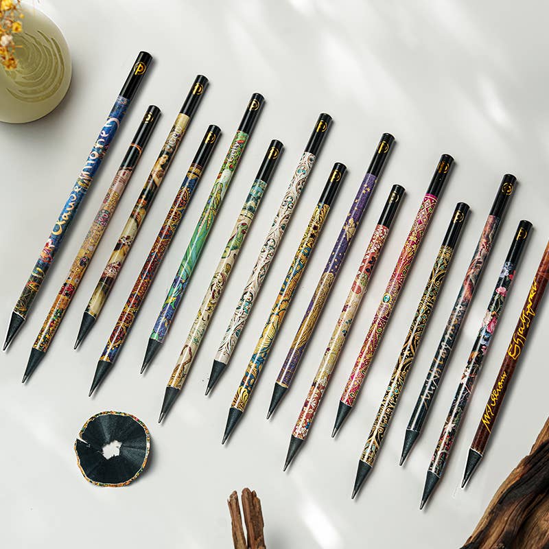 Set of intricately designed pens on a white surface with a small decorative item.