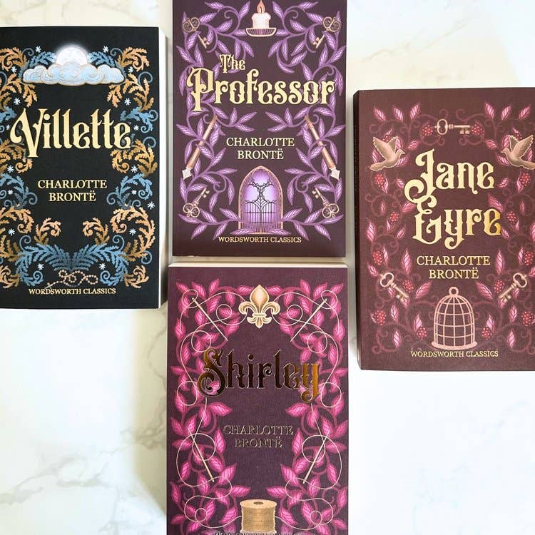 Four books by Charlotte Bronte with decorative covers on a white background
