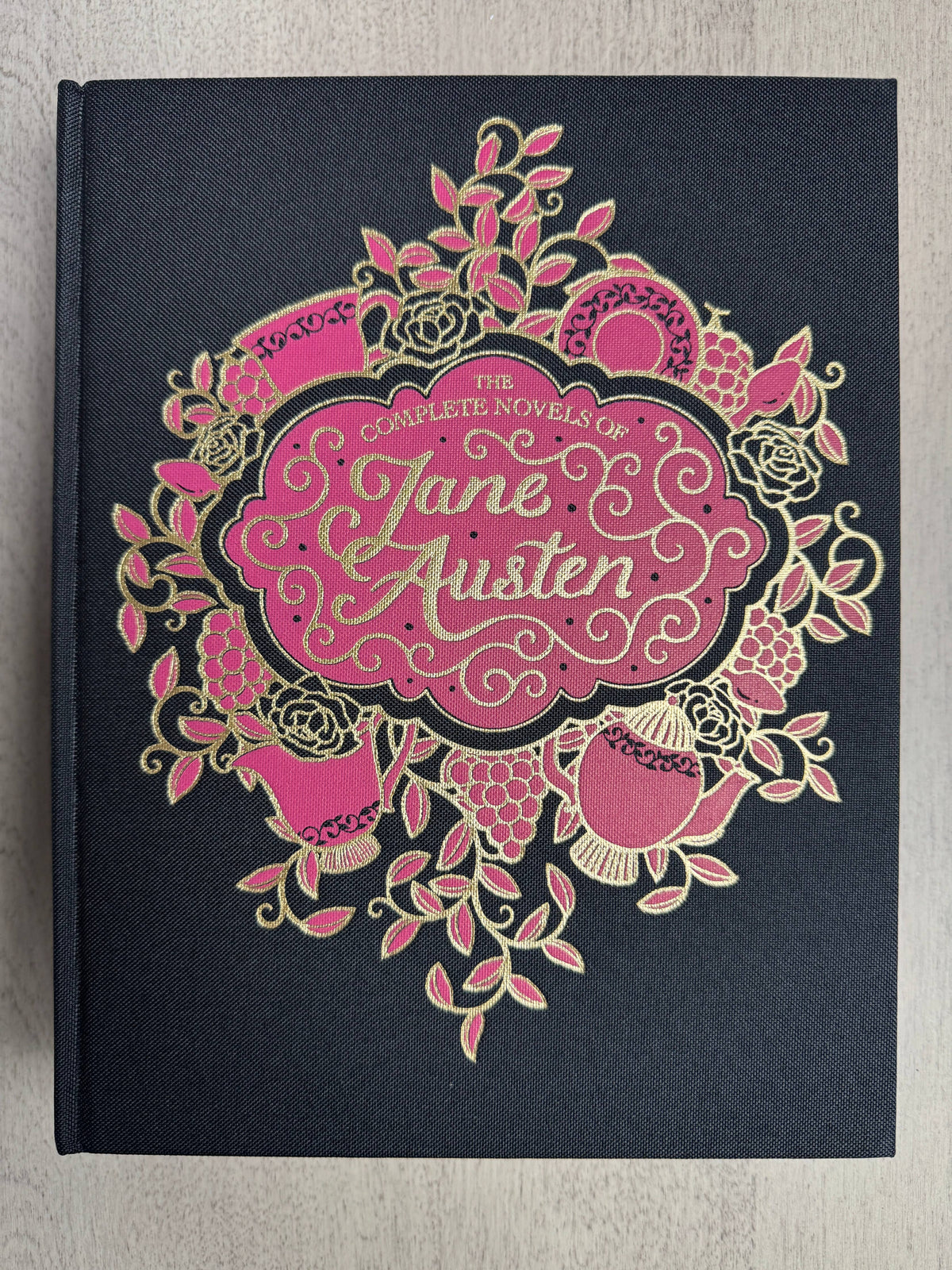 Jane Austen Complete Novels, Wordsworth Library Collection large hardcover book with black linen cloth binding, decorative gold foil details, colored page edges, and ribbon bookmark.