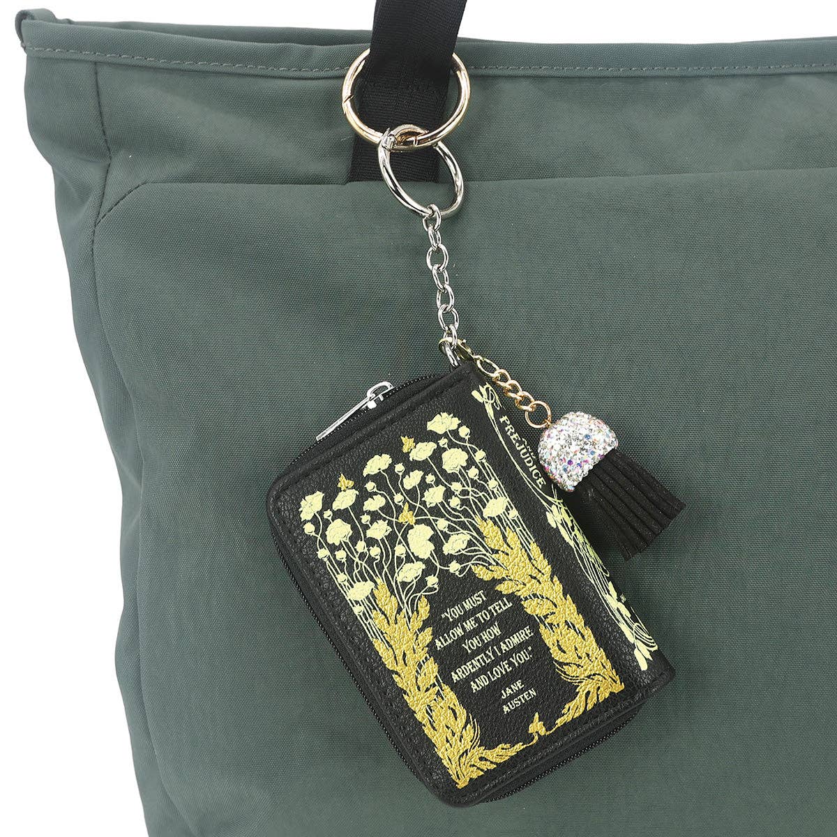 Keychain with book design and tassel attached to a green bag