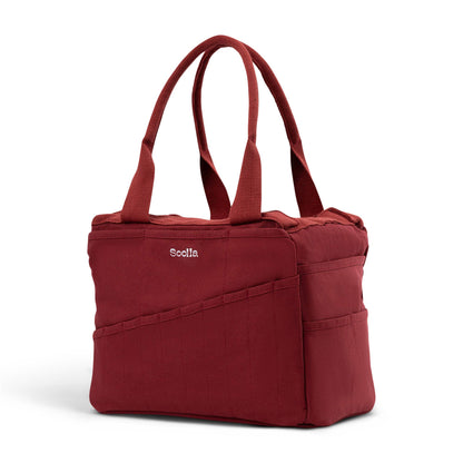 Soolla Studio Bag in Sangria, angled view showing the canvas body and storage pockets.