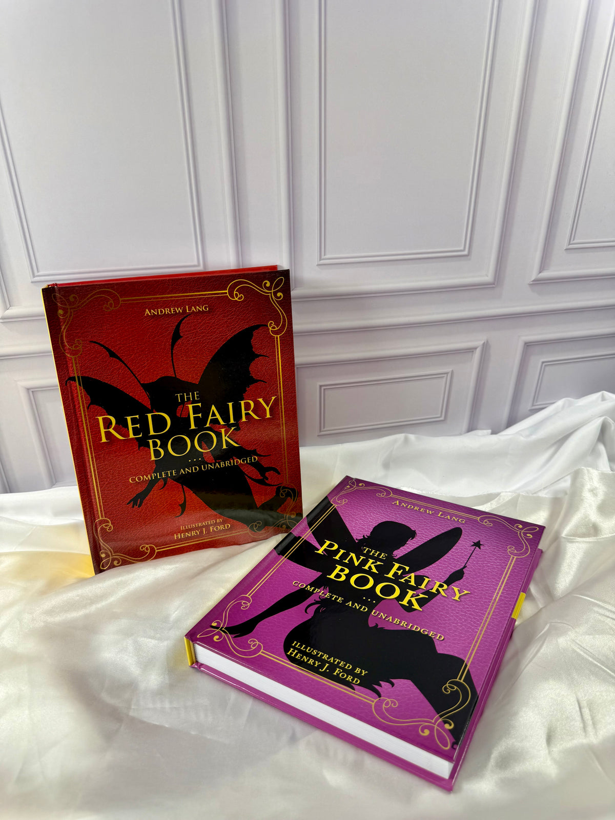 Two Andrew Lang Fairy Books displayed together: Red and Pink, with colorful illustrated covers.