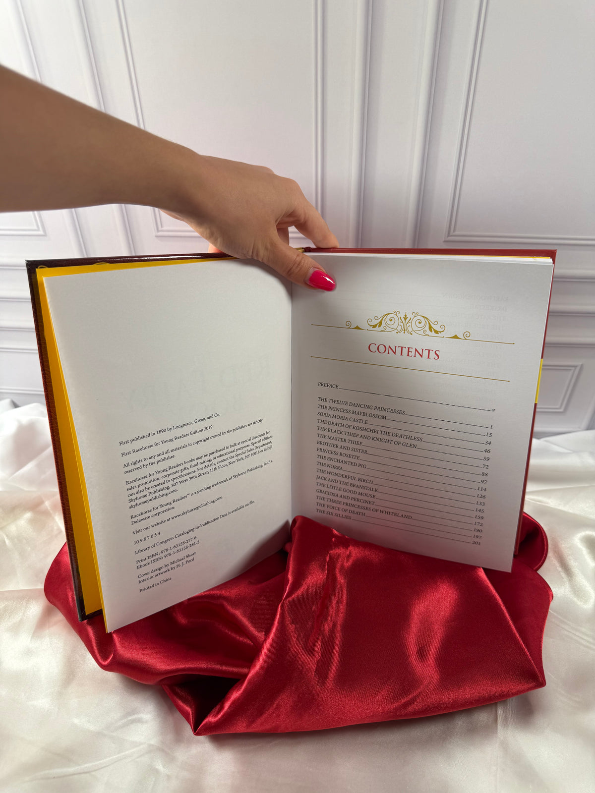 The Red Fairy Book by Andrew Lang opened to its table of contents, showing a selection of traditional fairy tales.