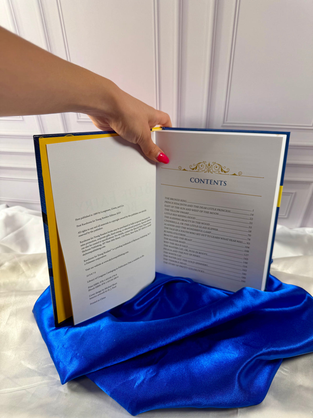 The Blue Fairy Book by Andrew Lang opened to its table of contents, featuring a selection of traditional fairy tales.