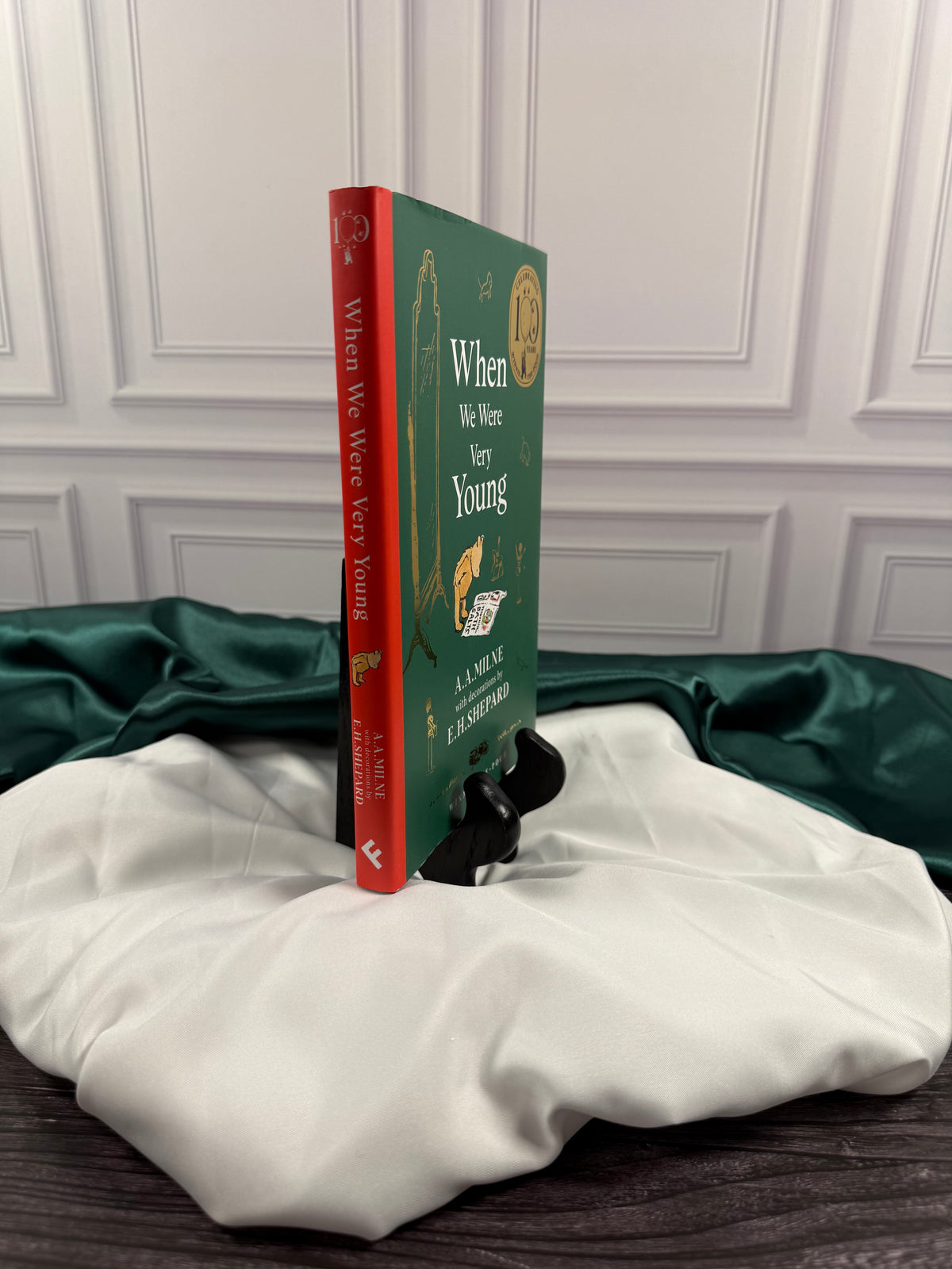 When We Were Very Young illustrated hardcover shown from the side, featuring its red spine, white title lettering, and green front cover.