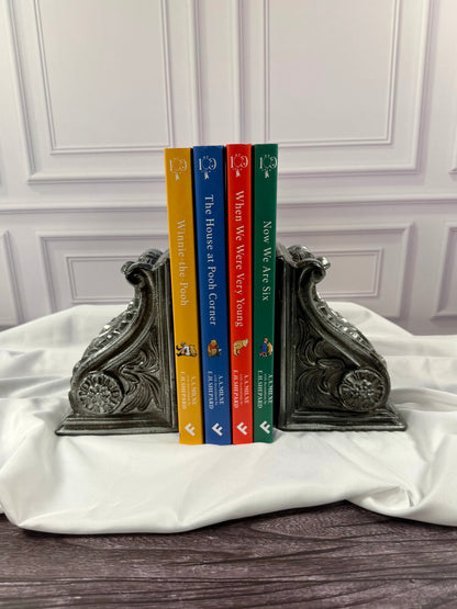 Four matching A. A. Milne 100th anniversary hardcover books displayed with colorful spines together: Winnie-the-Pooh, The House at Pooh Corner, When We Were Very Young, and Now We Are Six.