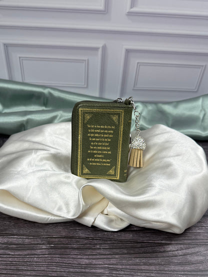 Back cover of The Little Mermaid book bag charm featuring gold decorative text and border on olive green vinyl, with silver keyring and tassel.