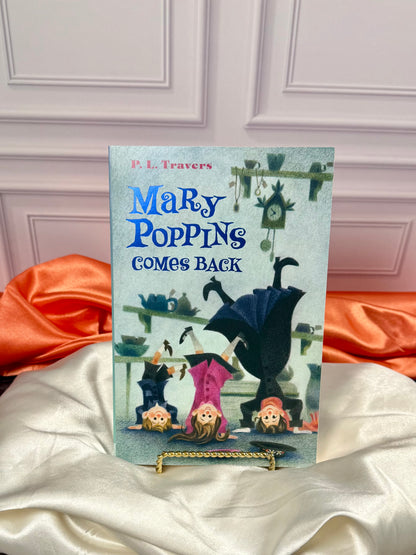Another illustrated Mary Poppins paperback from the four-book collection, displayed upright against a white paneled background with red satin fabric.
