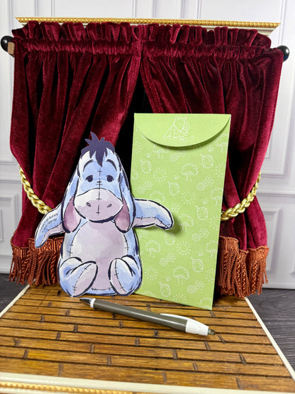 Disney Winnie the Pooh Hugs Eeyore character notecard shown folded with its arms enclosing a handwritten greeting.