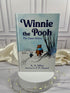 Winnie-the-Pooh by A. A. Milne illustrated hardcover book photographed in the StoryGiftStudio studio, showing its pale blue cover and classic Pooh artwork.