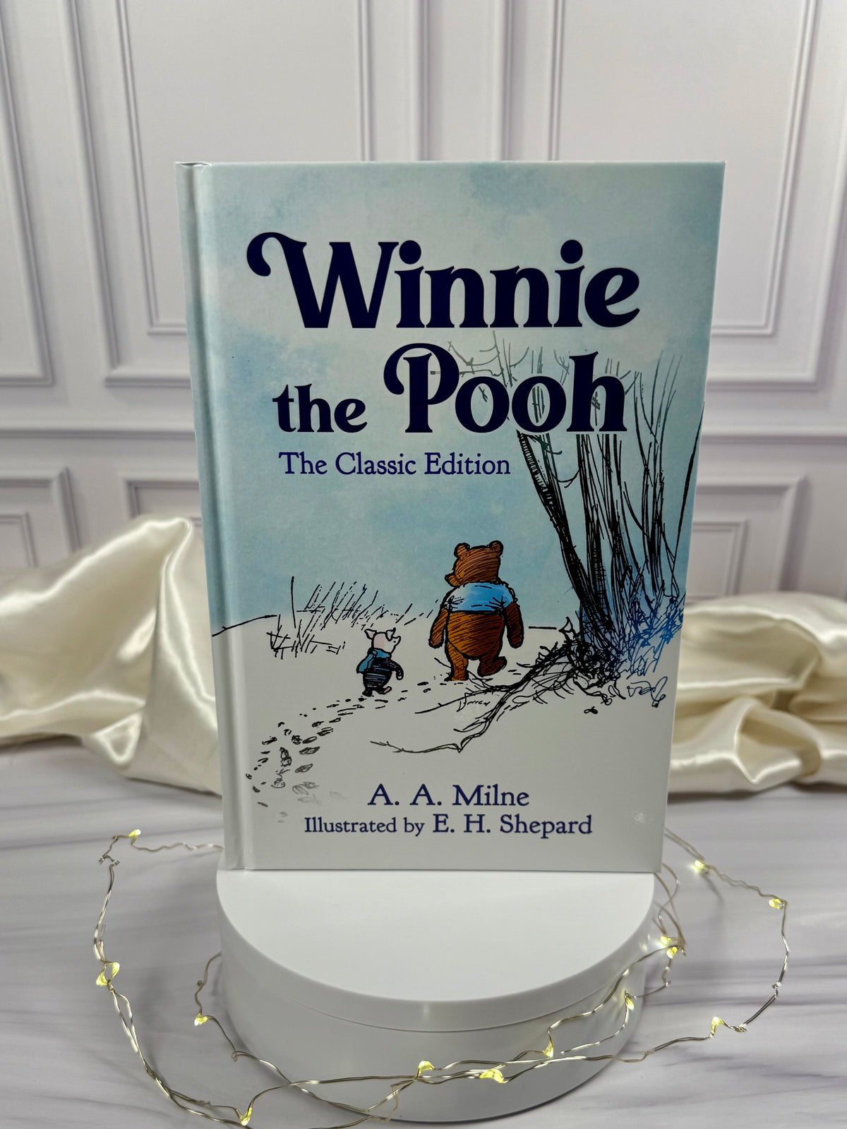 Winnie-the-Pooh illustrated hardcover book by A. A. Milne displayed upright in a StoryGiftStudio studio photograph.