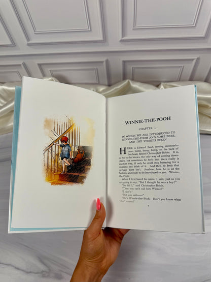 Open pages of Winnie-the-Pooh illustrated hardcover showing A. A. Milne&