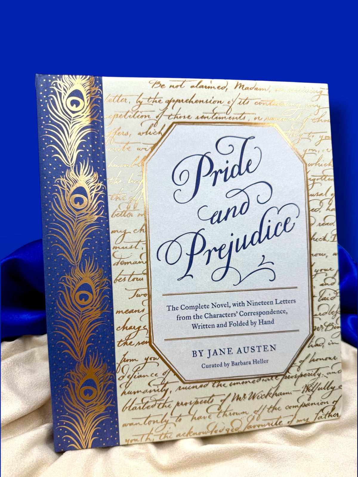 Pride and Prejudice by Jane Austen deluxe edition with removable letters, featuring an ornate blue and gold hardcover displayed on ivory satin.