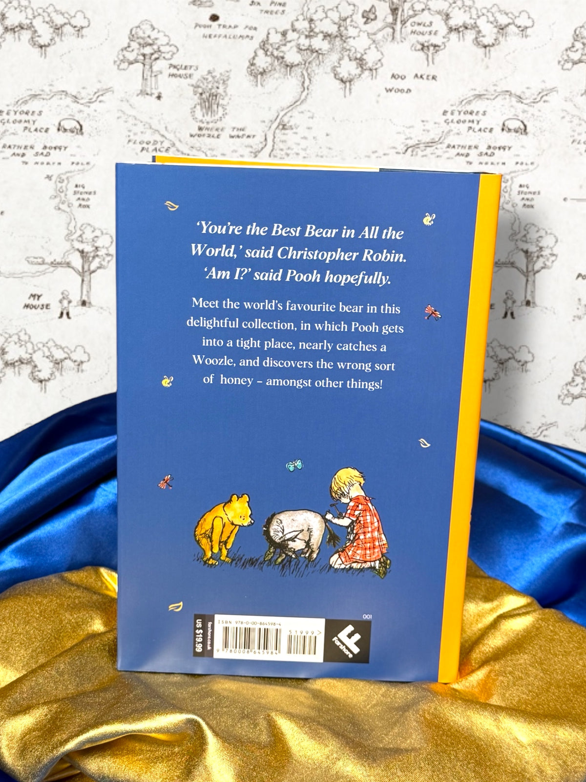 Back cover of Winnie-the-Pooh 100th anniversary hardcover featuring Christopher Robin, Pooh and Eeyore illustration