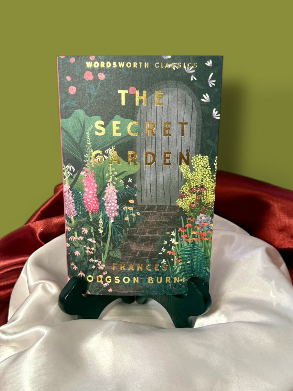The Secret Garden by Frances Hodgson Burnett, Wordsworth Classics paperback edition, showing its dark illustrated front cover with colorful floral artwork.