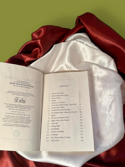 Open paperback edition of The Secret Garden by Frances Hodgson Burnett, photographed in the StoryGiftStudio™ studio to show the interior pages.