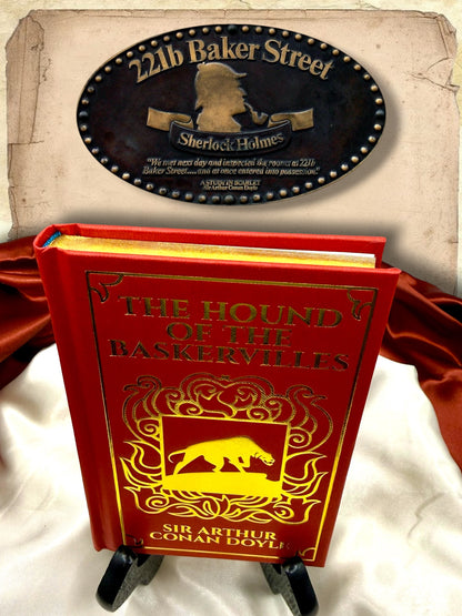 Close-up of The Hound of the Baskervilles decorative red hardcover showing the gold-embossed front cover and reflective gilded page edges.