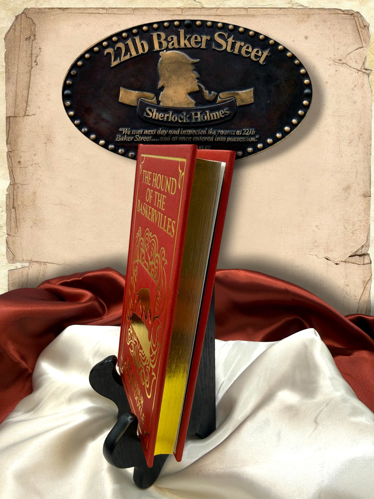 Side view of The Hound of the Baskervilles red clothbound hardcover showing its gold-gilded page edges, ornate cover design, and compact book format.