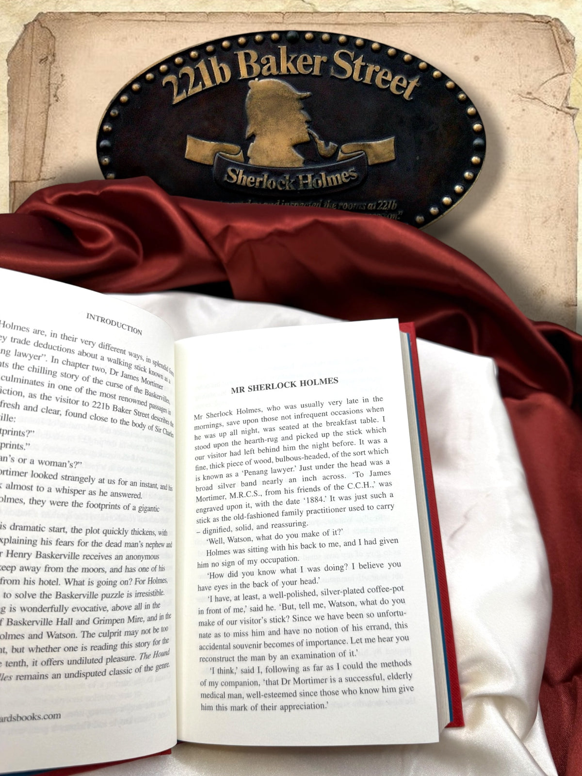 Open pages of The Hound of the Baskervilles showing the introduction and opening chapter Mr Sherlock Holmes, with black serif text printed on ivory paper.