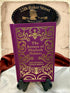 The Return of Sherlock Holmes by Sir Arthur Conan Doyle, purple clothbound hardcover with ornate gold cover decoration, displayed on a wooden stand in the StoryGiftStudio studio.