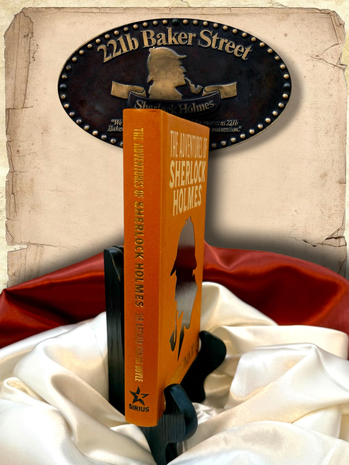Angled view of The Adventures of Sherlock Holmes orange hardcover showing gold lettering on the spine, Sir Arthur Conan Doyle&