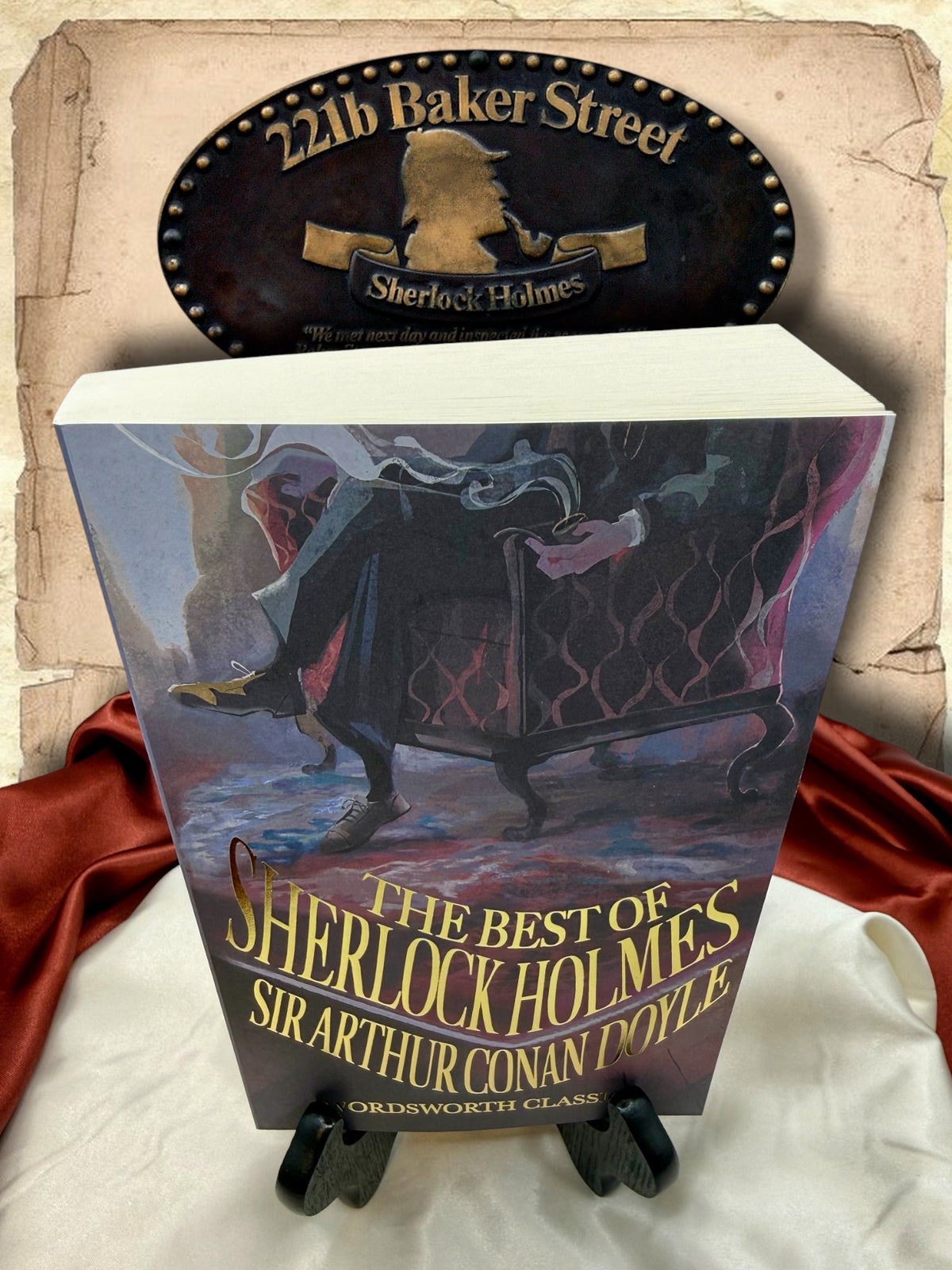 Angled view of The Best of Sherlock Holmes Wordsworth Classics paperback showing its illustrated front cover, gold title lettering, and thick block of white pages.