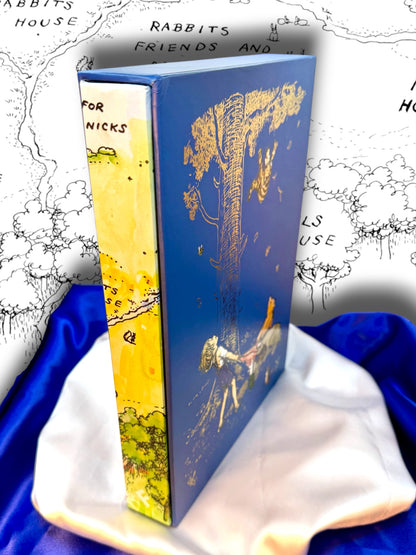 Winnie-the-Pooh complete collection slipcased hardcover by A. A. Milne shown at an angle, displaying the illustrated blue cover and spine on satin fabric.