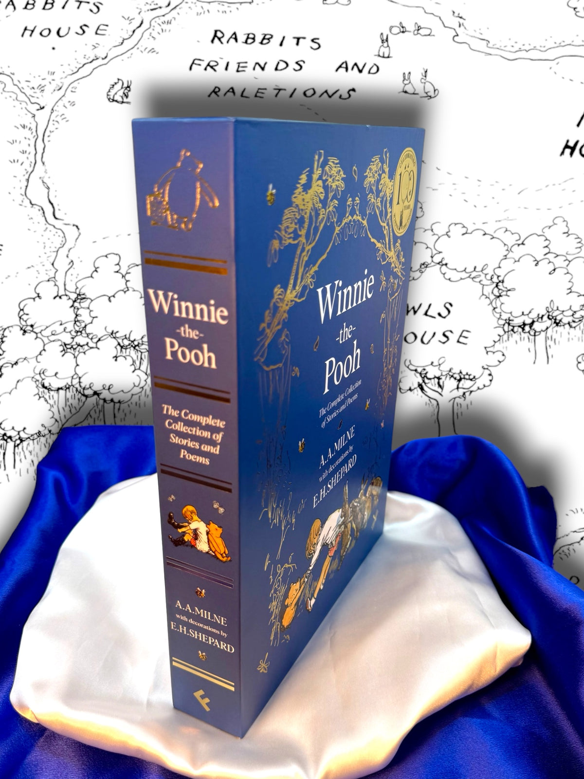 Winnie-the-Pooh complete hardcover collection by A. A. Milne displayed with its illustrated blue slipcase and decorative spine, photographed on blue and white satin.