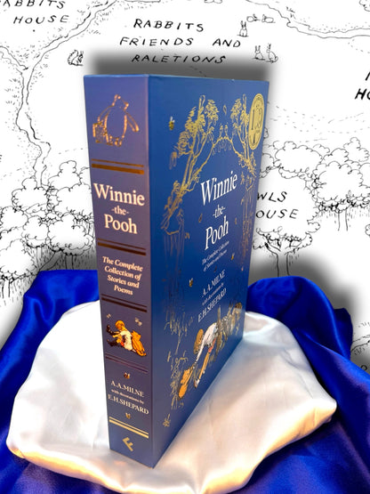 Winnie-the-Pooh complete hardcover collection by A. A. Milne displayed with its illustrated blue slipcase and decorative spine, photographed on blue and white satin.