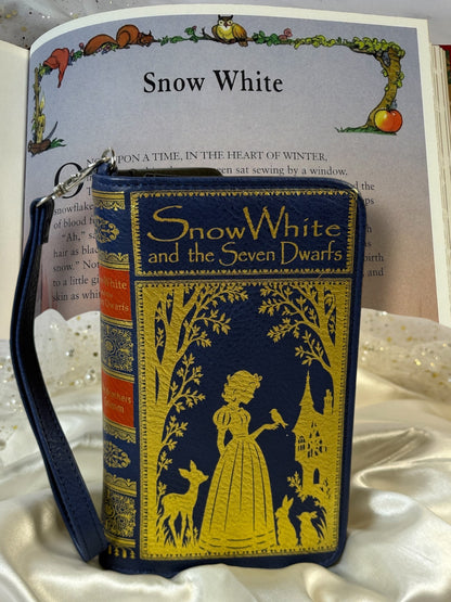 Snow White book wallet photographed with an open Snow White fairytale book page in the background.