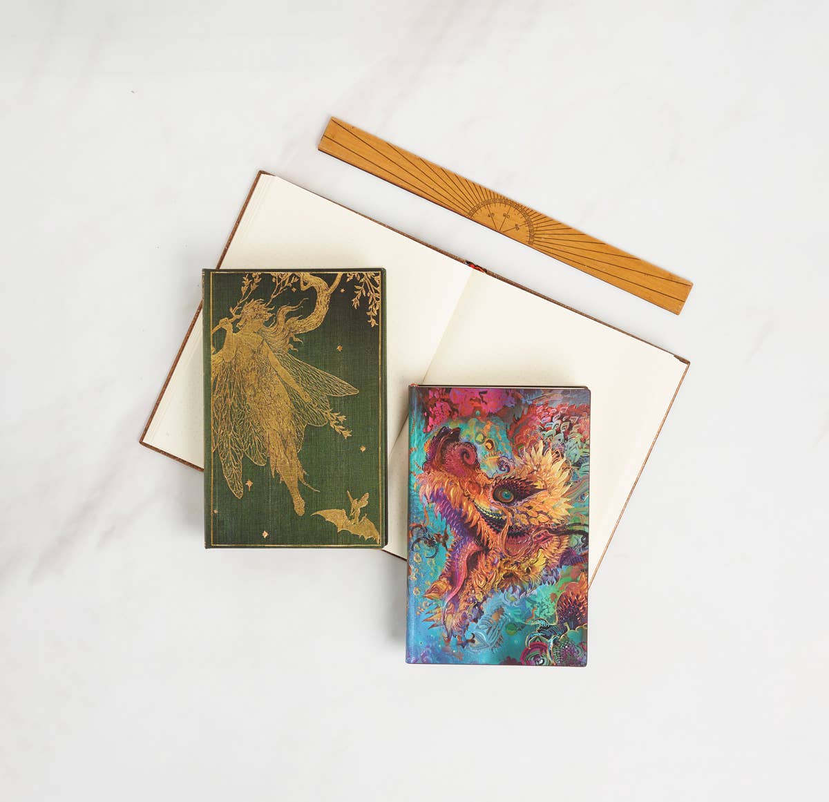 Two notebooks with fairy designs on a white background