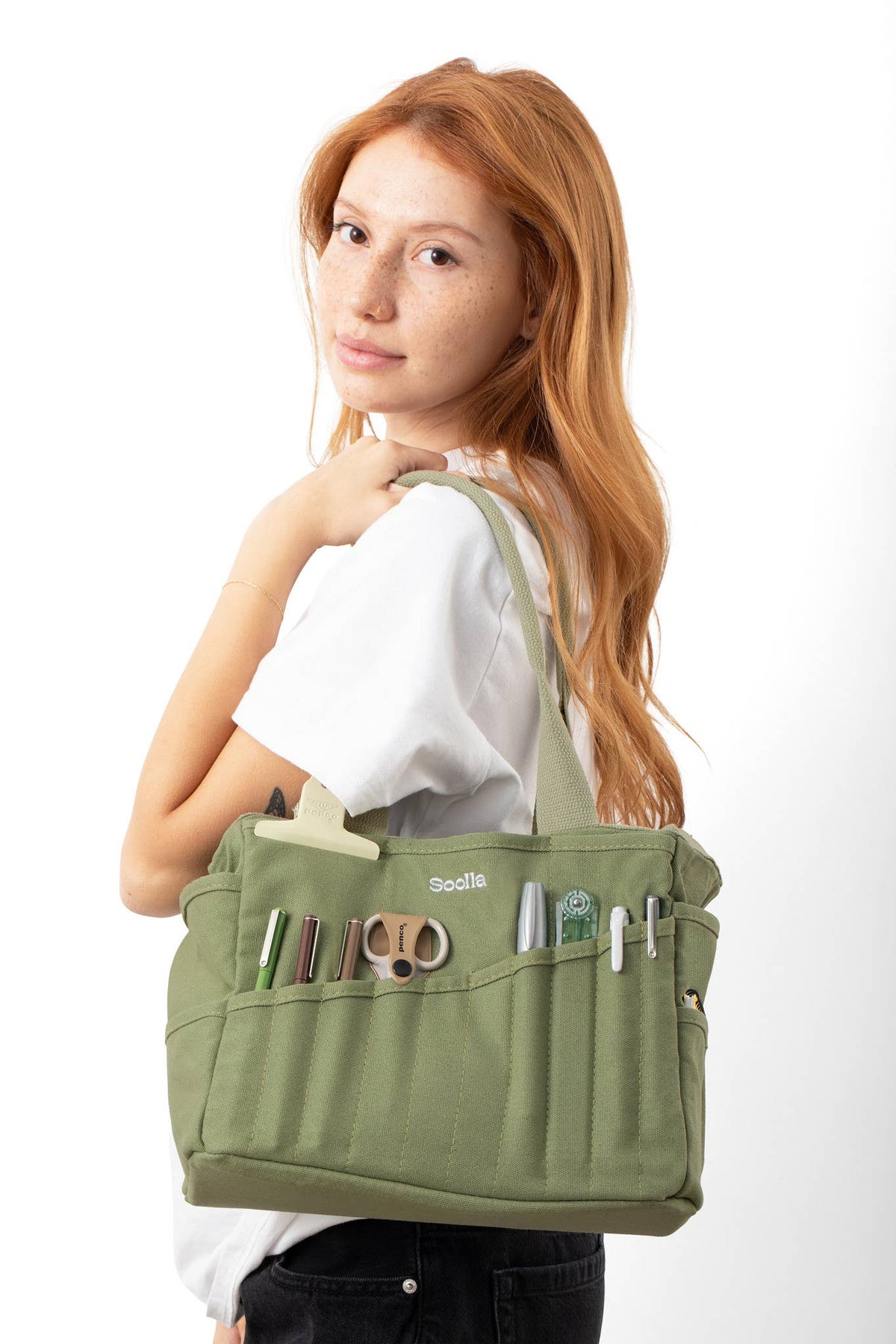 Woman carrying the ganja green Soolla Studio Bag over her shoulder.