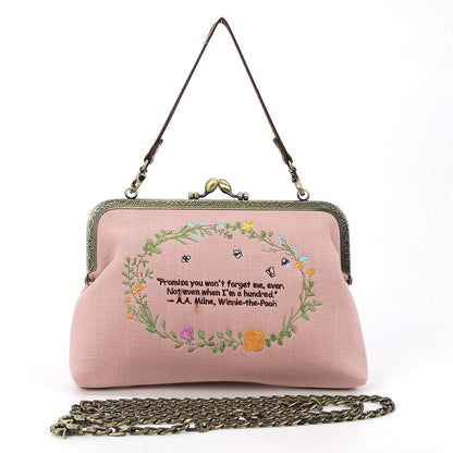 Back of pink Winnie-the-Pooh and Piglet kisslock handbag featuring an embroidered floral wreath and friendship quotation by A. A. Milne.