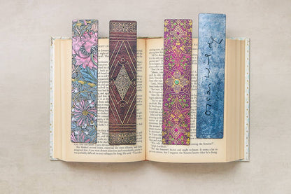 Open book with four colorful bookmarks on a neutral background