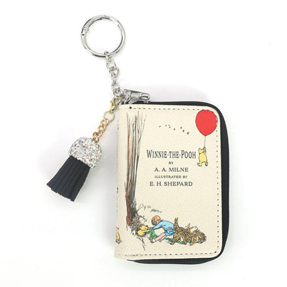Winnie the Pooh miniature book-shaped vinyl coin purse and bag charm featuring classic storybook-inspired cover artwork and a compact collectible design.