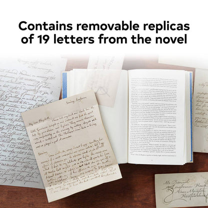 Open book with handwritten text and a letter on a wooden surface, with text overlay about removable replicas of letters from a novel.
