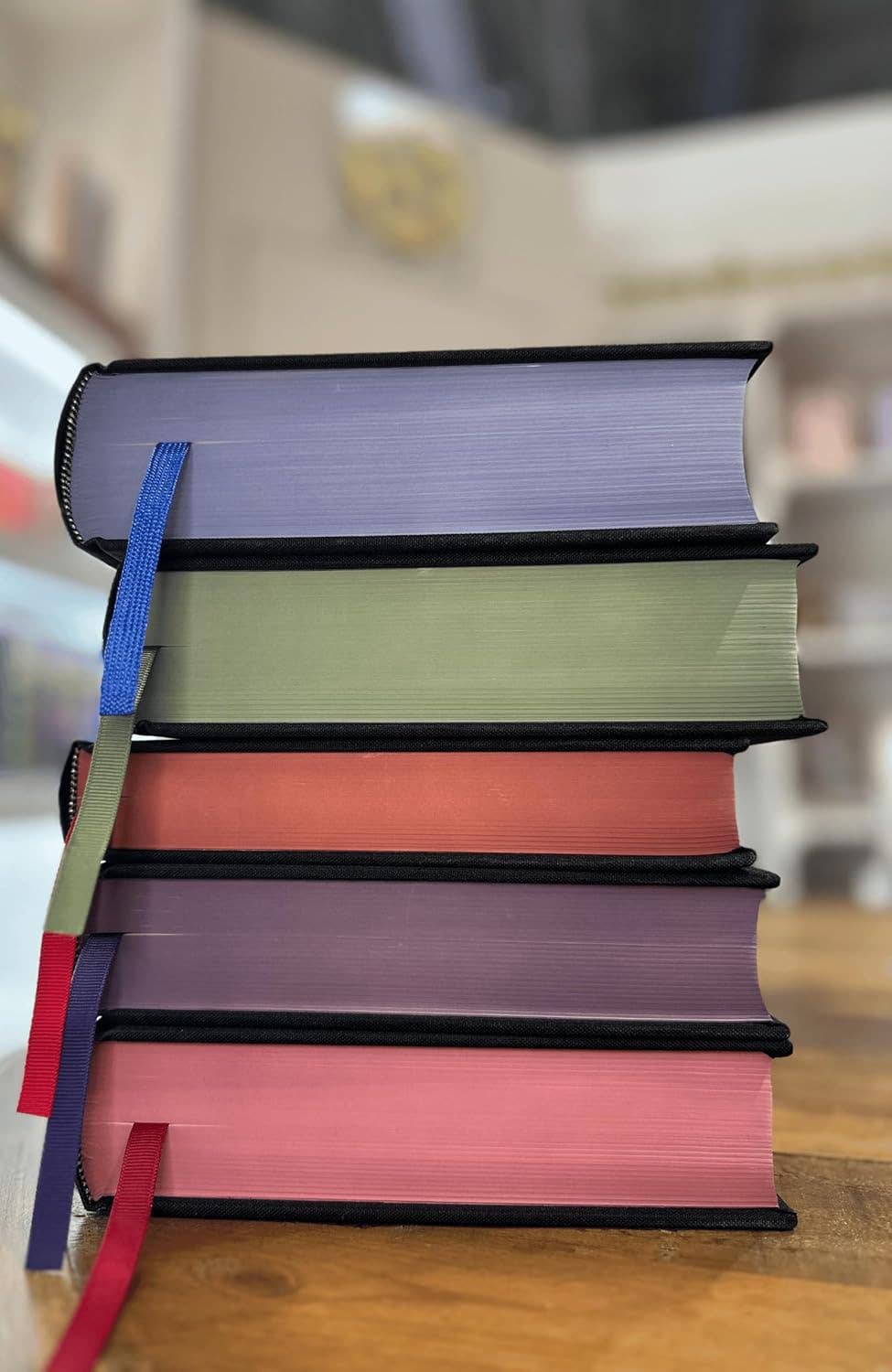 Stack of books with colorful ribbons on a wooden surface