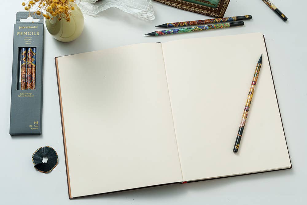 Open notebook with pencils and a pencil case on a light surface