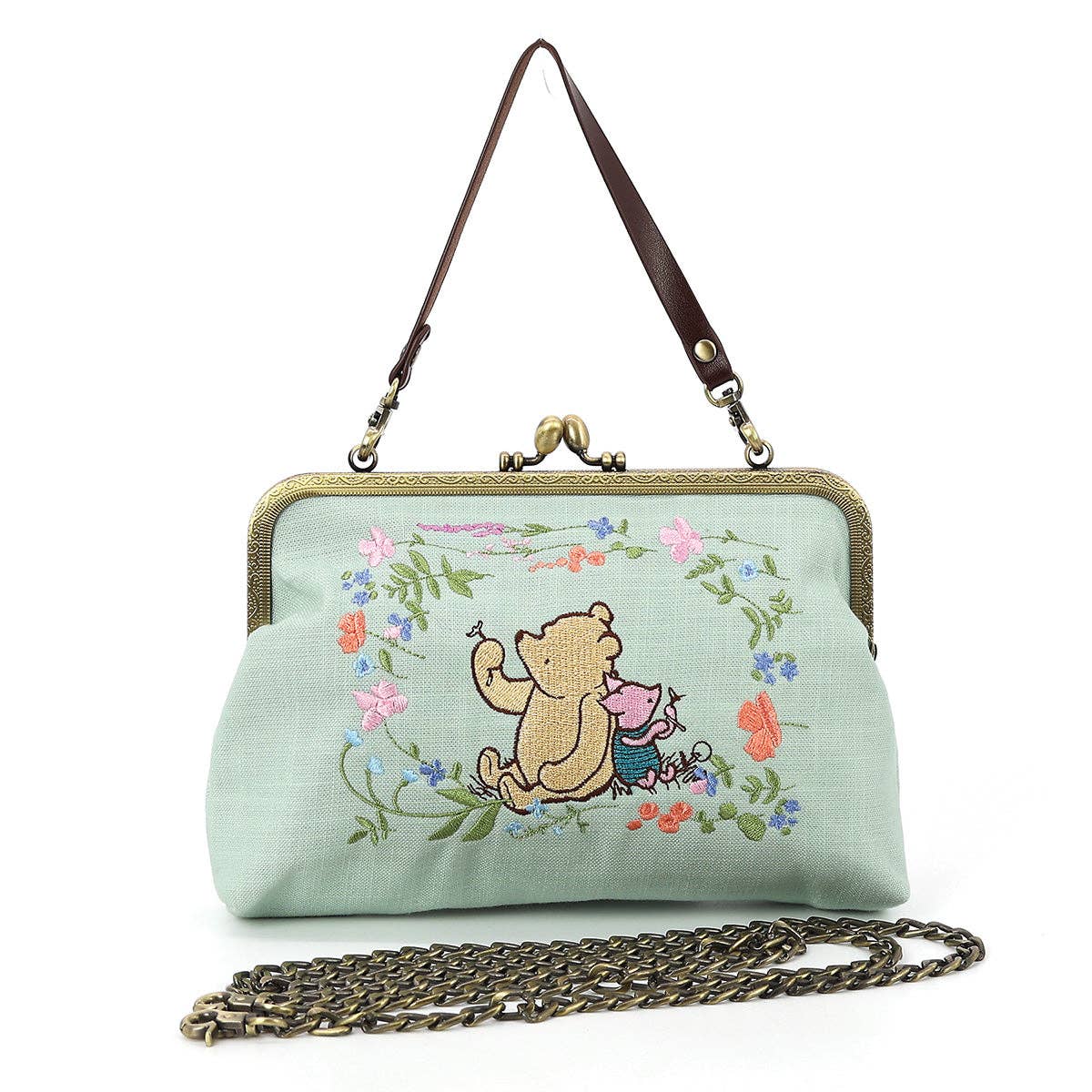 Winnie-the-Pooh and Piglet embroidered kisslock handbag in mint green linen blend with floral artwork, metal clasp, wrist strap, and chain shoulder strap.