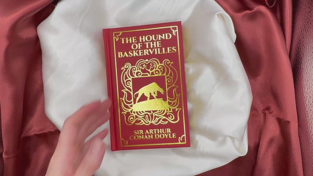 Video presentation of The Hound of the Baskervilles by Arthur Conan Doyle, a compact red clothbound hardcover with ornate gold decoration and gilded page edges.